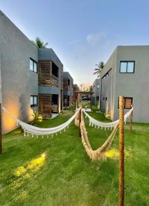 a yard with hammocks in front of a building at Praia do Patacho - Milagres in Pôrto de Pedras