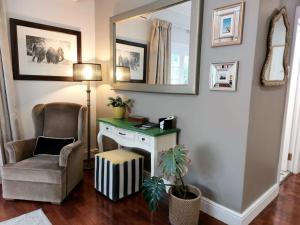 Una sala de estar con una silla y un espejo. en Daisy Place, en Franschhoek