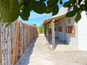 a wooden fence next to a house at Lá na Chay Caraíva Refúgio tranquilo & experiência local in Caraíva