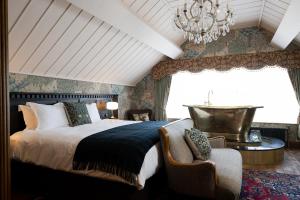 um quarto com uma cama grande e um lustre em The Old Inn em Crawfordsburn