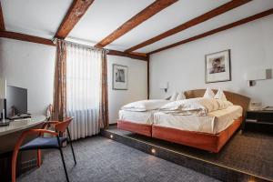 a bedroom with a bed and a desk and a computer at Hotel am Jakobsmarkt in Nuremberg