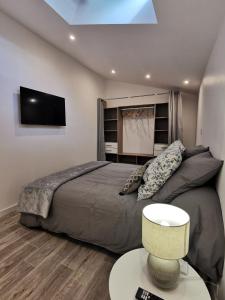 a bedroom with a bed and a tv on the wall at Loft 90m2 - Tout confort in Libourne