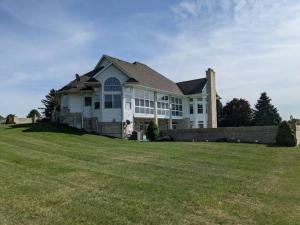 a large white house with a large grass field at HUGE Crystal Lake 7 Acre Ranch w Pool and Indoor Spa in McHenry