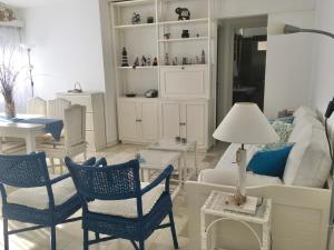 - un salon avec des fauteuils bleus et un canapé dans l'établissement Calle 20 Punta del Este, à Punta del Este