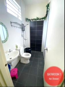 a bathroom with a white toilet and a sink at Hani Guest House Big House in Malacca