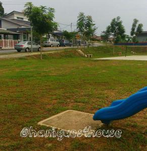 a playground with a blue slide in a park at Hani Guest House Big House in Melaka