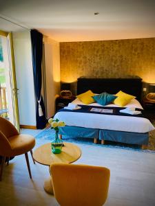 1 dormitorio con cama extragrande y mesa en Domaine Du Moulin Vallée Heureuse en Poligny
