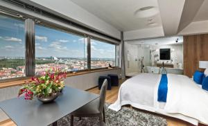 una camera d'albergo con letto e tavolo con vaso di fiori di SKY SUITE HOTEL a Praga