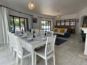 a dining room with a white table and chairs at Vivenda Júlia e Tavares in Vilamoura