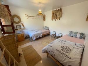 une chambre avec deux lits dans une pièce dans l'établissement We surf Morocco BOUTIQUE HOUSE, à Taghazout