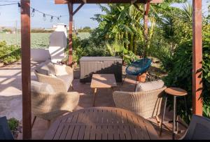 a patio with wicker chairs and a table and a table at Ca Emma in Mahuella