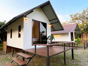 ein kleines Haus mit einer Veranda und einer Terrasse in der Unterkunft Pua Na Nan Camping ปัวนาน่านแคมป์ปิ้ง in Pua