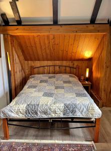 - une chambre avec un lit et un mur en bois dans l'établissement Ferienwohnung Kleinkögeln, 