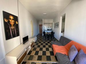 ein Wohnzimmer mit einem Sofa und einem karierten Boden in der Unterkunft UNU 1003 - Ondina, Carnaval, Orla, Vista, Wi-fi e+ in Salvador