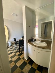 uma casa de banho com um lavatório, um espelho e uma mesa em UNU 1003 - Ondina, Carnaval, Orla, Vista, Wi-fi e+ em Salvador