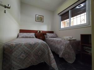a bedroom with two beds and a window at Nuestro Crepúsculo in San Juan