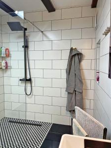 La salle de bains est pourvue d'une douche et d'une serviette accrochée au mur. dans l'établissement Ferienwohnung Kleinkögeln, 