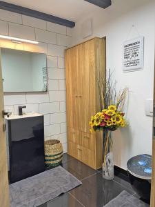 a bathroom with a sink and a vase of flowers at Ferienwohnung Kleinkögeln 