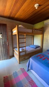 a bedroom with two bunk beds and a wooden ceiling at Canoa Abraão in Abraão