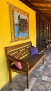 a wooden bench sitting on the side of a yellow wall at Canoa Abraão in Abraão