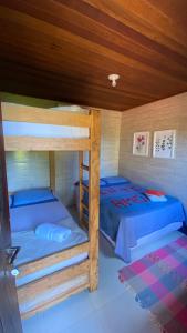a bedroom with two bunk beds and a wooden ceiling at Canoa Abraão in Abraão