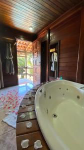 a large bath tub in a room with wooden walls at Canoa Abraão in Abraão