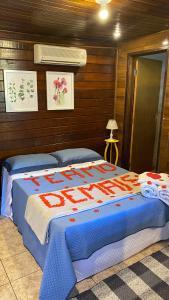 a bedroom with a bed with a blue and red blanket at Canoa Abraão in Abraão