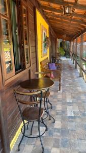a porch with tables and chairs on a building at Canoa Abraão in Abraão