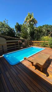 a swimming pool on a wooden deck with a bench next to it at Canoa Abraão in Abraão