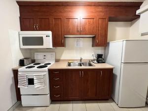 a kitchen with a white stove and a sink at Motel Du Chevalier in Gatineau