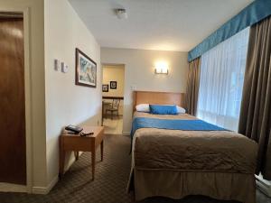 a hotel room with two beds and a window at Motel Du Chevalier in Gatineau