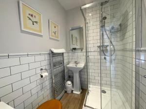 a bathroom with a shower and a sink and a toilet at The Jug And Bottle in Heswall
