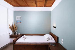 een slaapkamer met een bed met witte lakens en een houten plafond bij OVGORA - Aretousa sea view room, Kamilari village in Kamilari