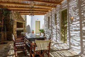 a wooden table and chairs on a patio at Villa Isabella Family villa close to the beach in Mikonos