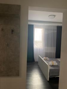 1 dormitorio con cama y ventana en Apartman Mici en Niš