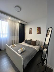a bedroom with a large bed with towels on it at Apartman Mici in Niš
