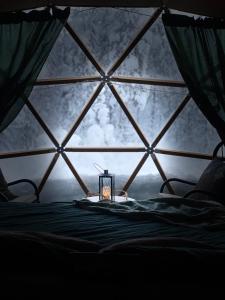 a room with a window with a bed and a candle at Pandomes Aurora Igloo Hotel in Rovaniemi