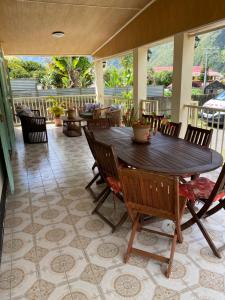 a porch with a wooden table and chairs at La Cayenne in Salazie