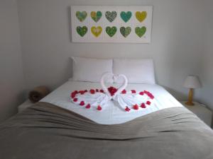 uma cama com um coração feito de rosas em Pousada Chalés dos Montes em Santana dos Montes