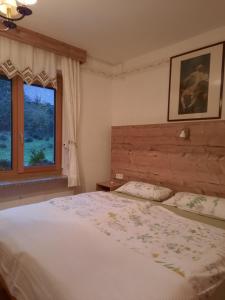 una camera con un grande letto e una finestra di Chalet Damtschach a Damtschach