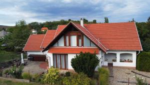 ein weißes Haus mit orangefarbenem Dach in der Unterkunft Diófás Guesthouse in Rózsaszentmárton