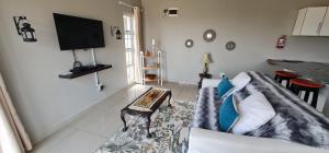 a living room with a couch and a table at Cosy Cottage in Port Shepstone