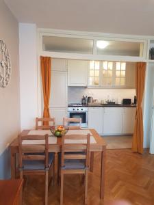 cocina y comedor con mesa de madera y sillas en Apartment Neven, en Varna