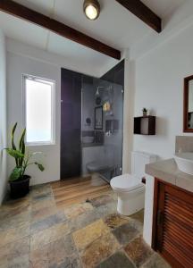 a bathroom with a toilet and a shower and a sink at Semilla Verde Boutique Hotel in Puerto Ayora