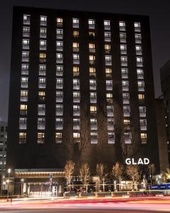 un grand bâtiment la nuit avec une rue devant dans l'établissement GLAD Yeouido, à Séoul