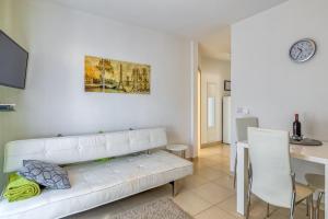 a living room with a white couch and a table at Apartments Kardumovic in Poreč