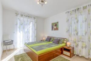 1 dormitorio con 1 cama en una habitación con ventanas en Apartments Kardumovic, en Poreč