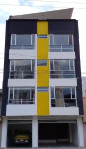 派帕的住宿－Apartamentos Edificio Premium，前面有一辆汽车的黄色和白色建筑