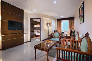 a living room with a couch and a tv at ASTON Karimun City Hotel in Tanjung Balai Karimun