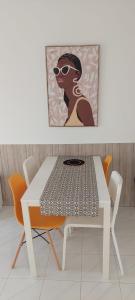 una mesa y sillas blancas con una foto de una mujer en Casa Ayla Montecastillo A8, en Caleta de Fuste
